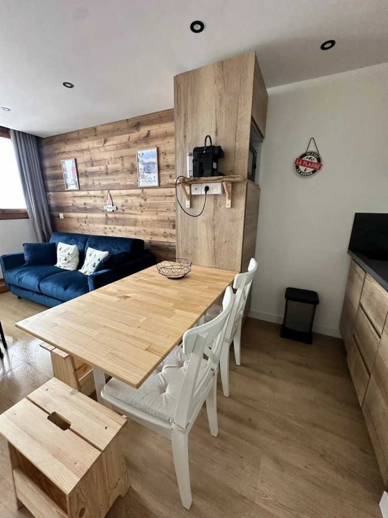 Cuisine équipée en bois clair et coin repas de l'appartement Dou du Praz
