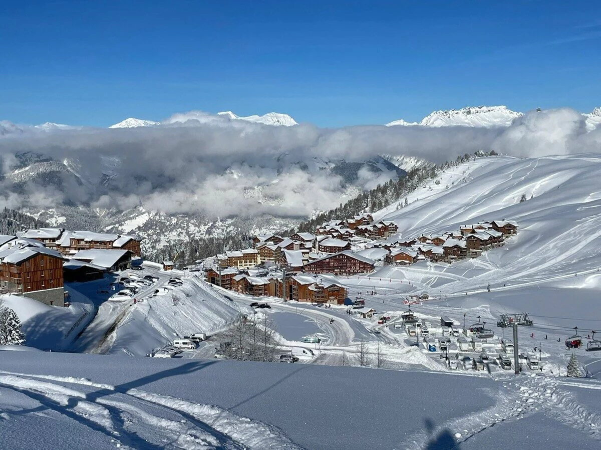 Plagne Villages sous la neige au-dessus d'une mer de nuages, sommets de la Tarentaise au loin