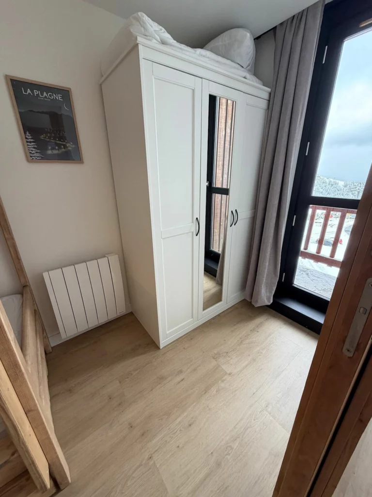 Armoire de rangement et porte-fenêtre donnant sur le balcon