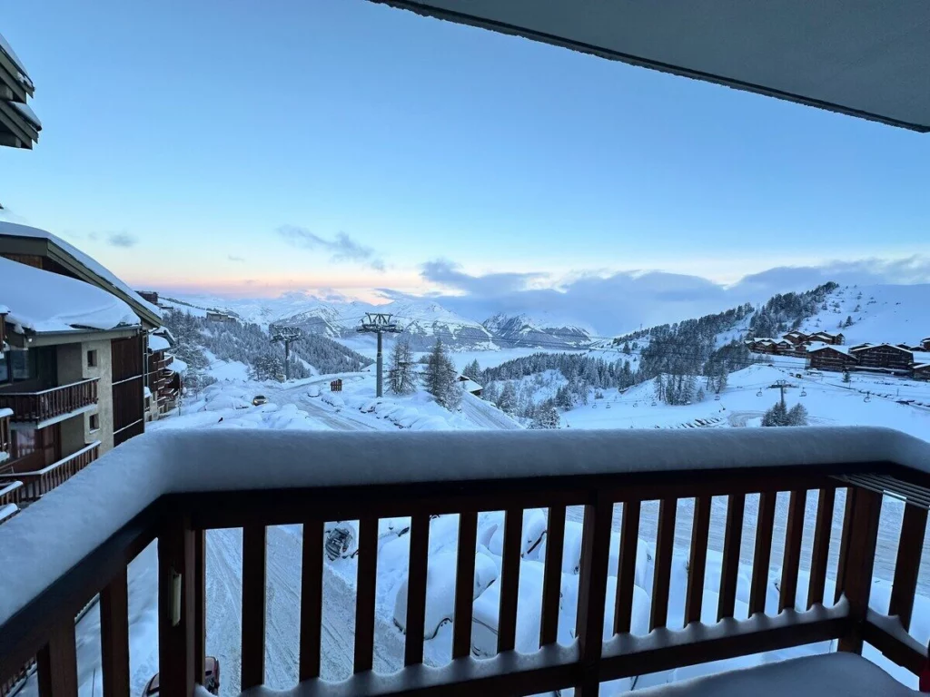 Vue matinale depuis le balcon sur les montagnes et la station enneigée